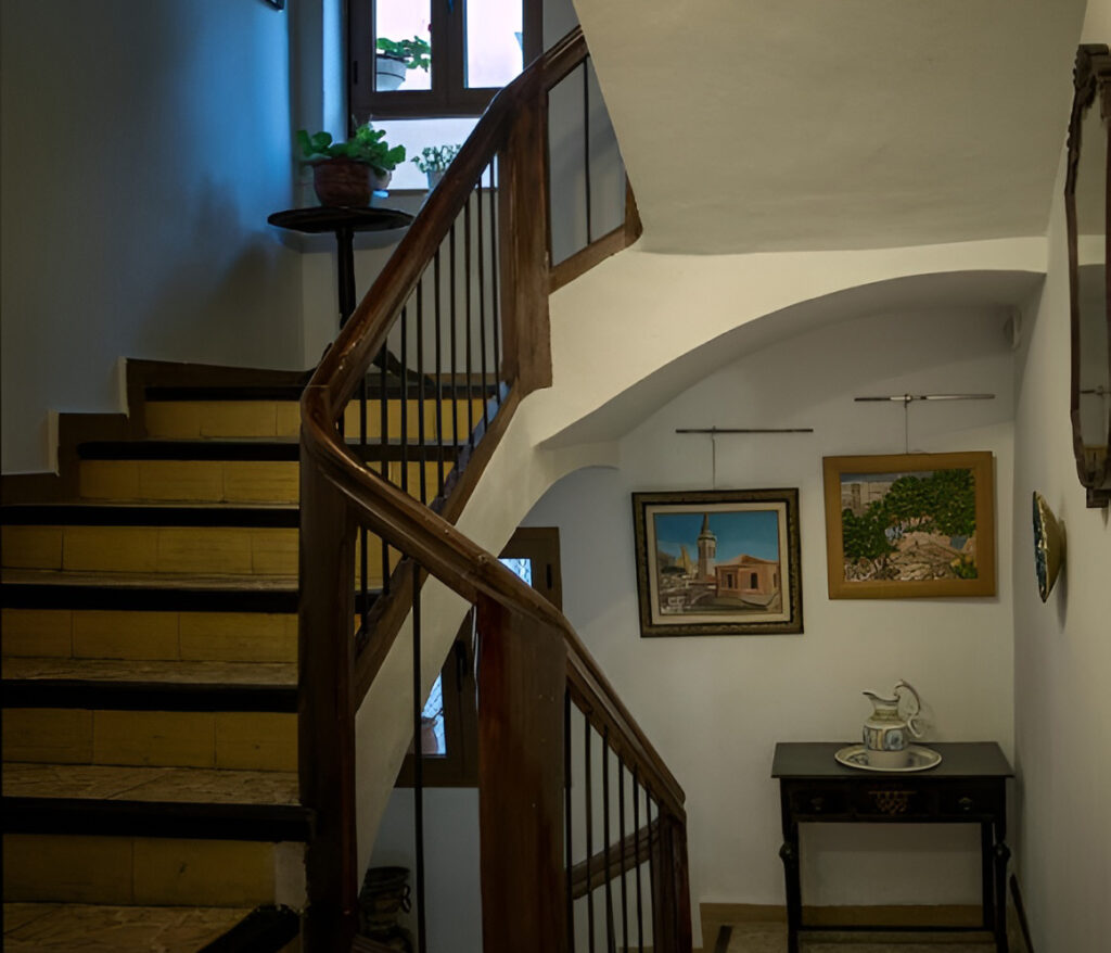 Vista de zona común del Hostal con la escalera en primer plano